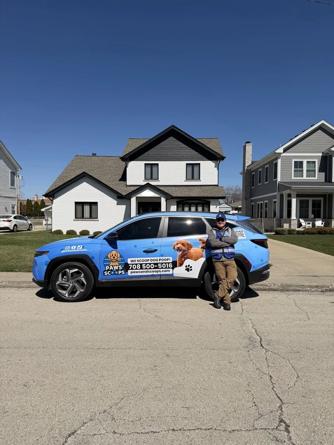 Paws and Scoops branded service vehicle parked outside a residential property